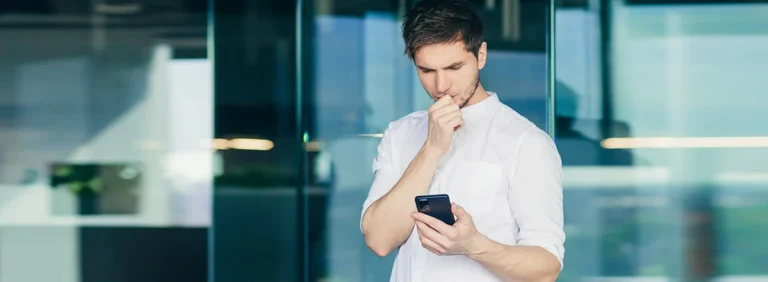 Homem preocupado segurando celular que está reiniciando sozinho