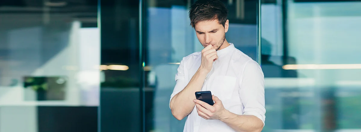Homem preocupado segurando celular que está reiniciando sozinho